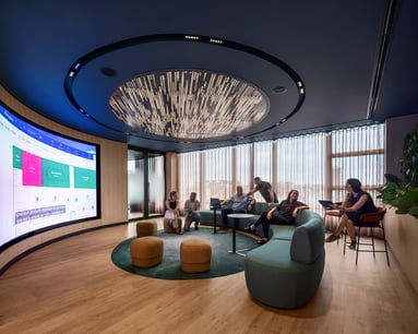People sitting on couch around large screen collaborating. 